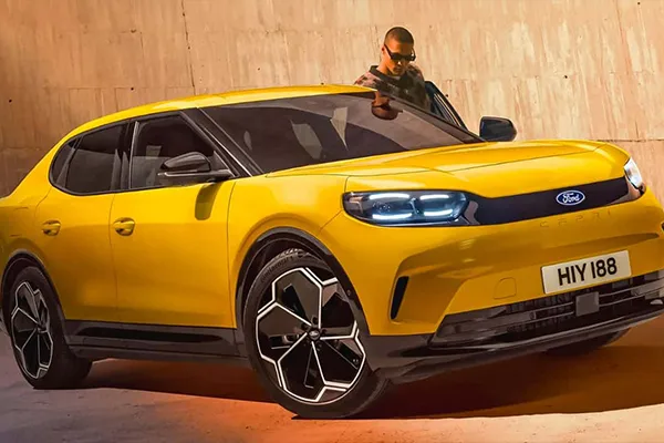 Junger Mann mit Sonnenbrille steigt in den neuen vollelektrischen Ford Capri SUV ein.