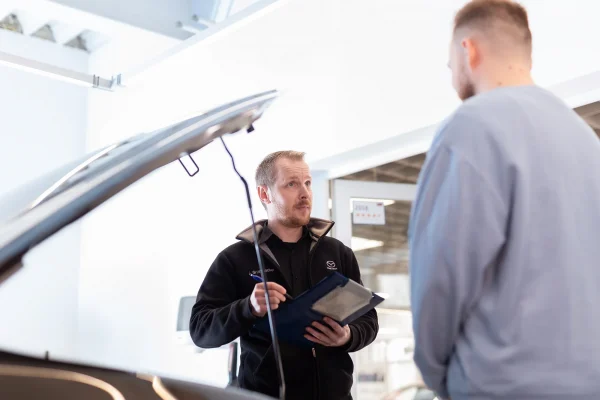 Ford-Serviceberater des Autohauses Hempel in der Direktannahme mit einem Kunden an dessen Fahrzeug.