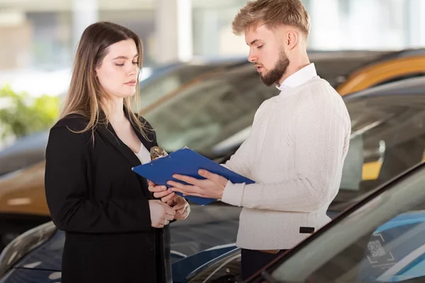 Ford-Verkäufer des Autohauses Hempel in Braunschweig bei der freundlichen Beratung einer Kundin in einem Ford-Modell.